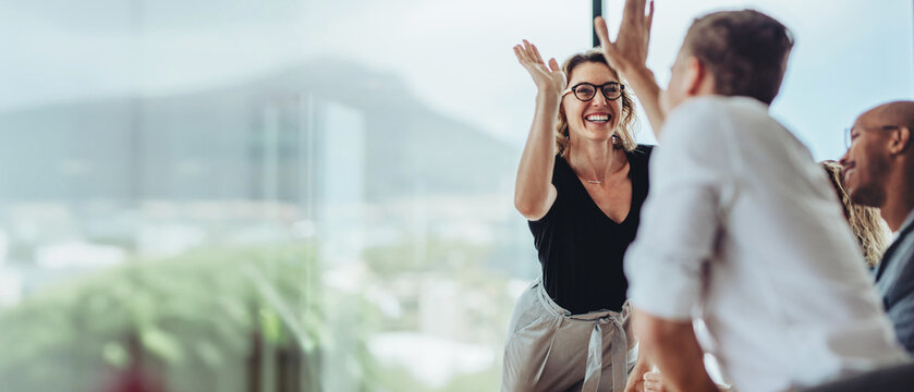 Business woman giving a high five to a colleague