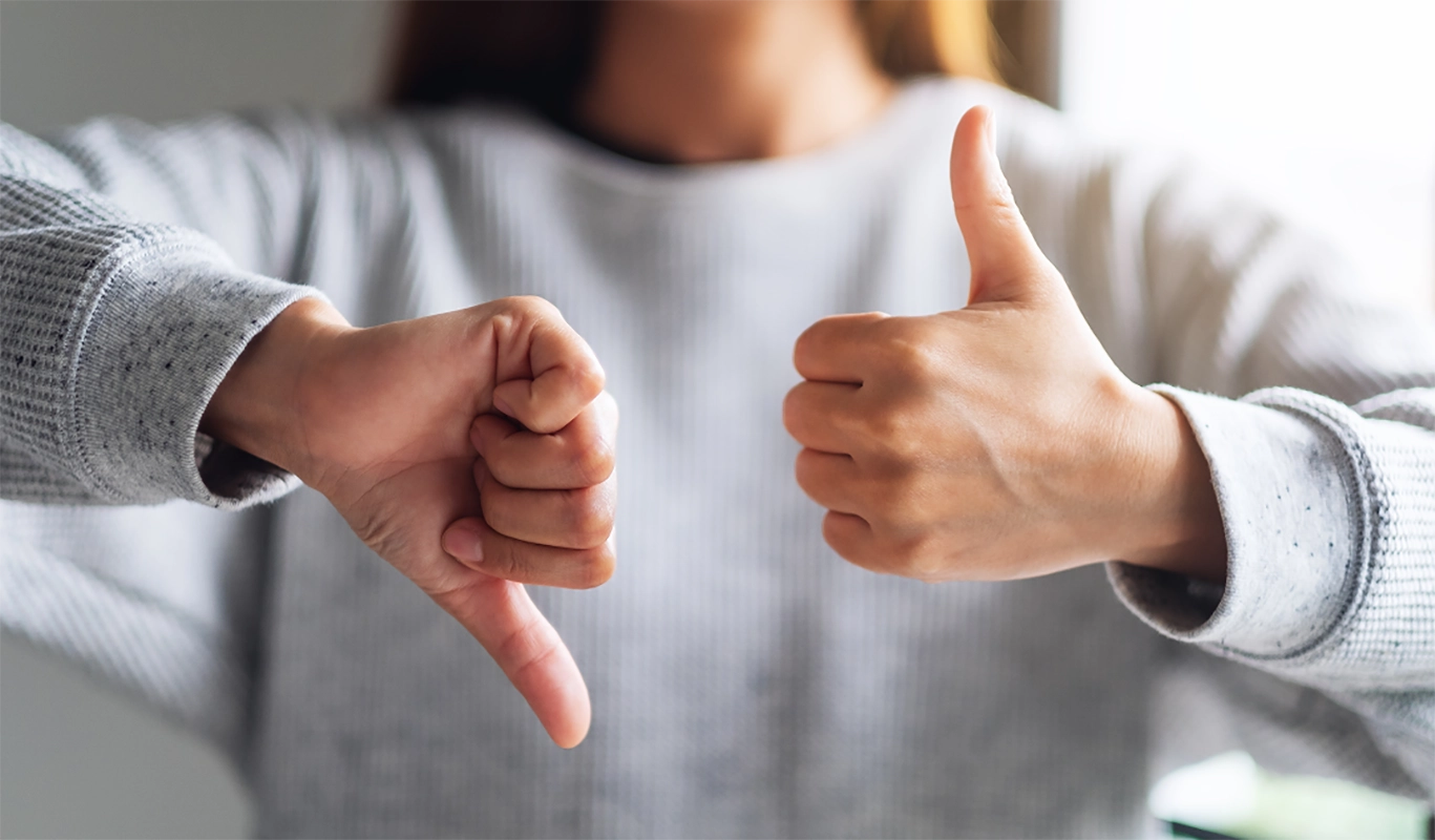 person holding thumbs up and down