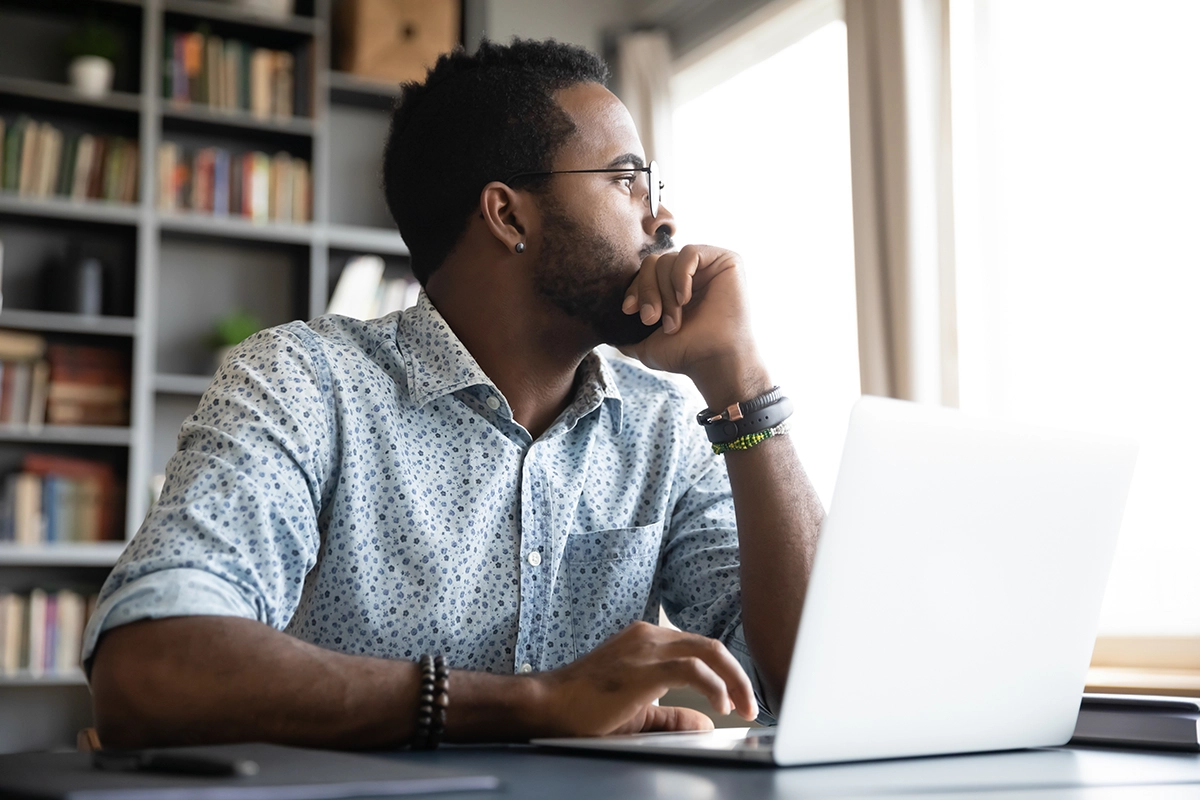 man in front of laptop in deep thought