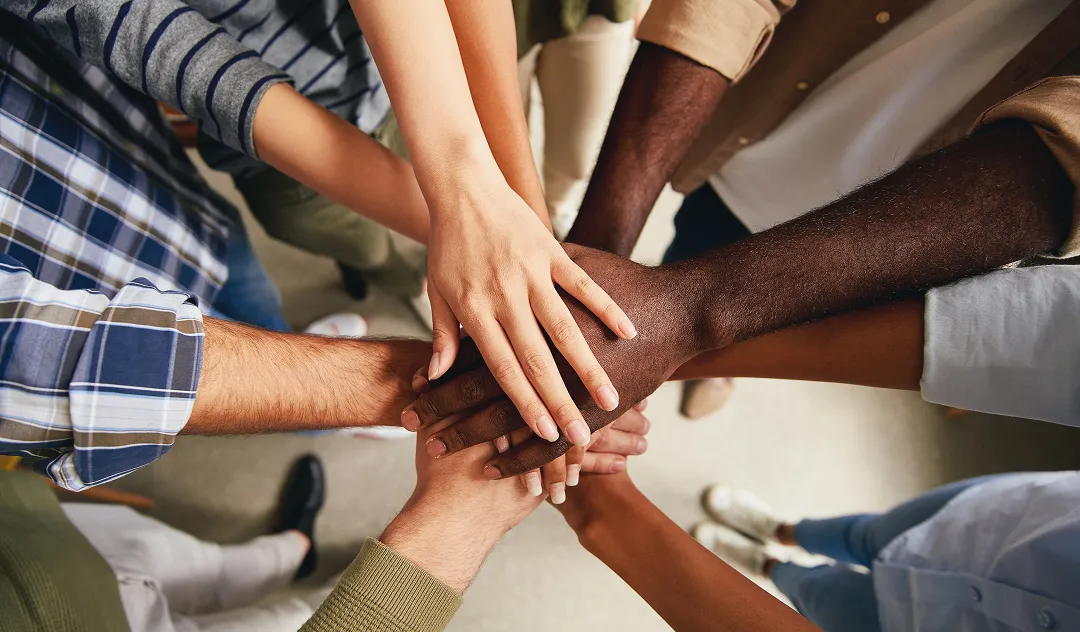 Hands on top of one another in a circle
