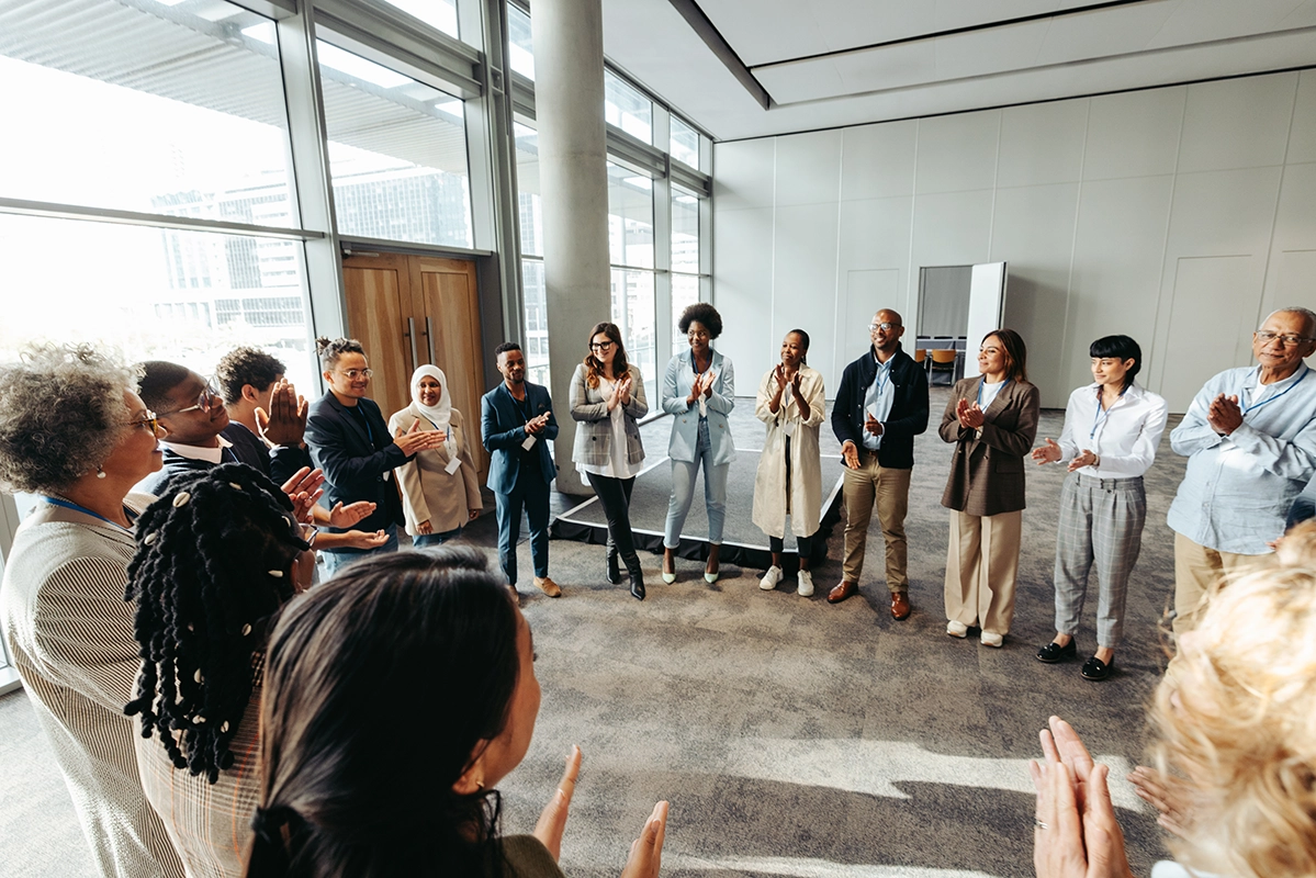 Large room full of people standing in a circle