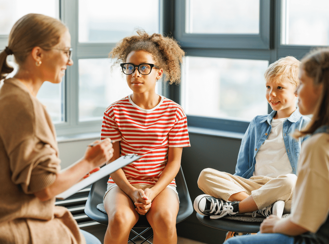 An adult professional female in a group with children.